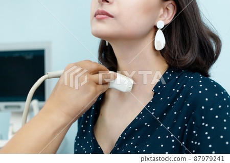 Examining patient thyroid gland woman using ultrasound scanner machine 87979241