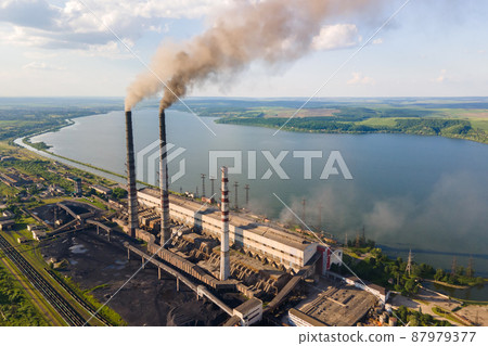 Aerial view of coal power plant high pipes with black smokestack polluting atmosphere. Electricity production with fossil fuel concept. Aerial view of coal power plant high pipes with black smokestack polluting atmosphere. Electricity production with fossil fuel concept. 87979377