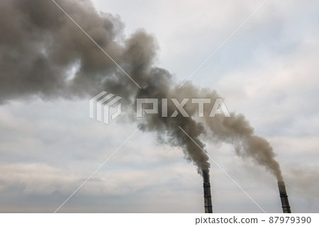 Aerial view of coal power plant high pipes with black smoke moving up polluting atmosphere. Aerial view of coal power plant high pipes with black smoke moving up polluting atmosphere. 87979390