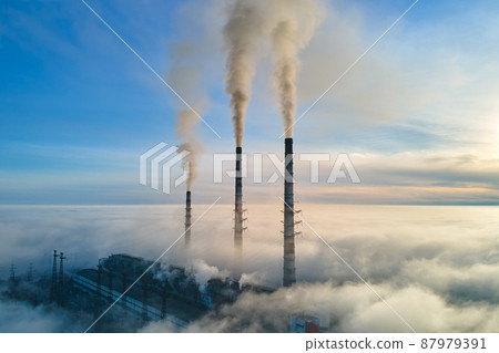 Aerial view of coal power plant high pipes with black smoke moving up polluting atmosphere at sunset Aerial view of coal power plant high pipes with black smoke moving up polluting atmosphere at sunset 87979391