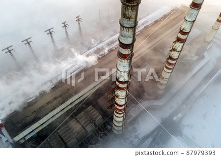 Aerial view of coal power plant high pipes with black smoke moving up polluting atmosphere at sunset. Aerial view of coal power plant high pipes with black smoke moving up polluting atmosphere at sunset. 87979393
