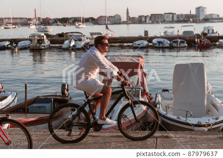 Senior couple enjoying a beautiful morning together riding a bike by the sea. Selective focus 87979637