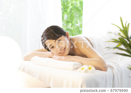 在熱帶度假勝地接受美容治療並微笑的女人 87979890