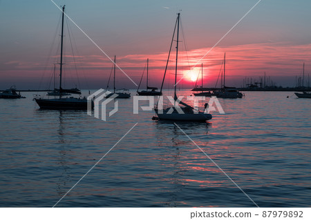 Sunrise on the seashore. In the silhouette of the ships in the harbor. Selective focus Sunrise on the seashore. In the silhouette of the ships in the harbor. Selective focus 87979892