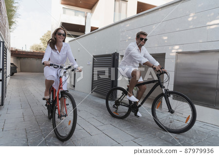 Senior couple enjoying a beautiful morning together riding a bike. Selective focus Senior couple enjoying a beautiful morning together riding a bike. Selective focus 87979936