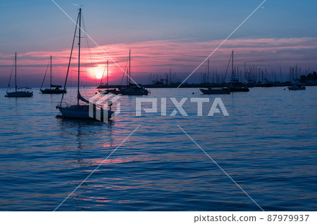 Sunrise on the seashore. In the silhouette of the ships in the harbor. Selective focus Sunrise on the seashore. In the silhouette of the ships in the harbor. Selective focus 87979937