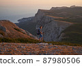 Hike mountain man hiking travel with backpack and trekking poles walking at adventure and sunset. with a smile. High quality photo. 87980506