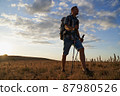 Hike mountain man hiking travel with backpack and trekking poles walking at adventure and sunset. High quality photo. 87980526