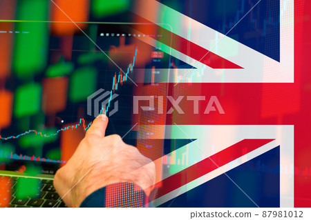 UK uptrend of the economy. Man hand shows on the increasing candle stick graph chart in the stock market with the flag on the background, March 2022, San Francisco, USA 87981012
