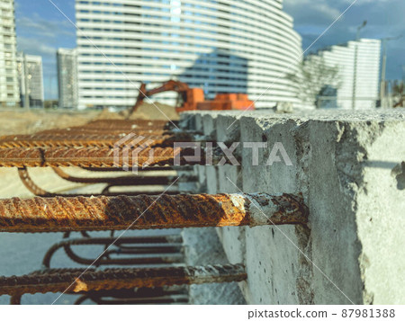 construction of a new area of the city. on the road are pieces of rebar. rusty and old pieces of metal stick out of the concrete block. rebar embedded in concrete 87981388