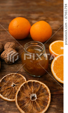 Sweet orange jam or marmalade dessert with walnuts on wooden background Sweet orange jam or marmalade dessert with walnuts on wooden background 87981794