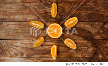 Citrus composition, orange in the shape of sun on the wooden background. Citrus composition, orange in the shape of sun on the wooden background. 87981808