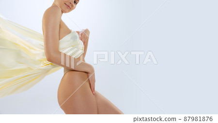 Cropped portrait of perfect smooth female body covered with silk fabrik isolated over gray studio background. Flyer 87981876