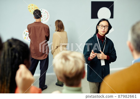 Asian Guide Talking To Tourists 87982661