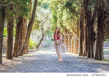 Woman tourist walking together in Montenegro. Panoramic summer landscape of the beautiful green Royal park Milocer on the shore of the the Adriatic Sea, Montenegro Woman tourist walking together in Montenegro. Panoramic summer landscape of the beautiful green Royal park Milocer on the shore of the the Adriatic Sea, Montenegro 87982922
