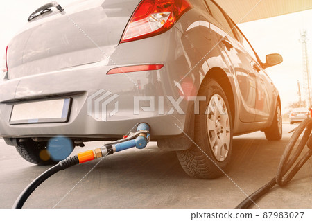 Pumping gas fuel car at oil station. Woman hand refuel petrol nozzle tank. Refueling transportation and Automotive industry. 87983027