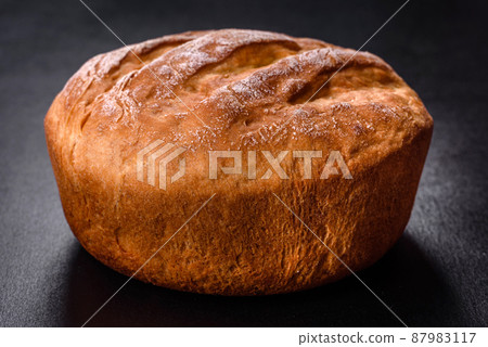 Tasty fresh baked in oven white bread on a dark concrete background 87983117