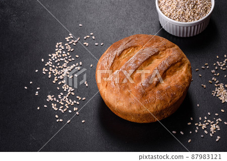 Tasty fresh baked in oven white bread on a dark concrete background Tasty fresh baked in oven white bread on a dark concrete background 87983121