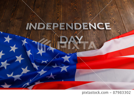 the words independence day laid on brown wooden planks surface with crumpled united states of america flag 87983302