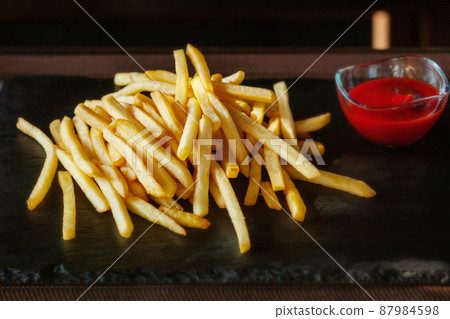 Deep fried potatoes with sauce. French fries and tomato sauce or ketchup. Deep fried potatoes with sauce. French fries and tomato sauce or ketchup. 87984598