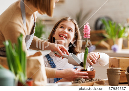 Mom and kid doing home gardening together 87984887