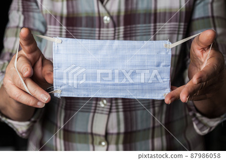 Person holding handmade hand-sewn face mask 87986058