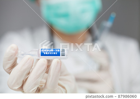 Scientist or doctor holding a vaccine ampoule injection 87986060