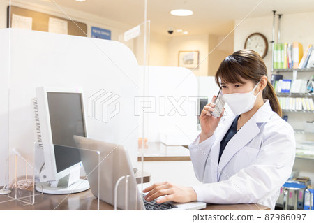 A woman working in a dispensing pharmacy A woman working in a dispensing pharmacy 87986097