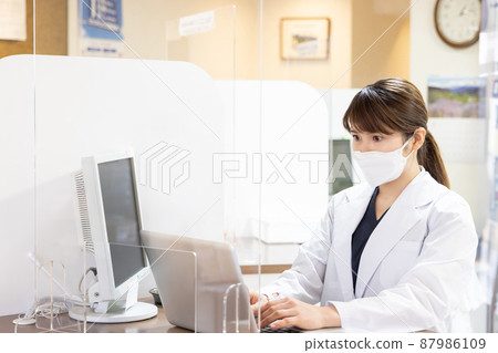 A woman working in a dispensing pharmacy 87986109