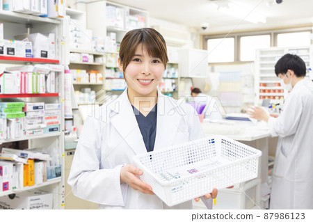 A woman working in a dispensing pharmacy 87986123