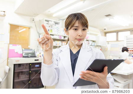 A woman working in a dispensing pharmacy 87986203