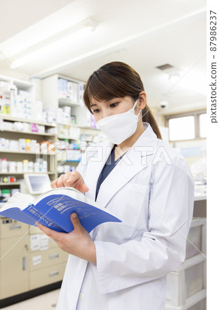 A woman working in a dispensing pharmacy 87986237