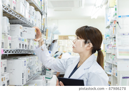 A woman working in a dispensing pharmacy 87986278