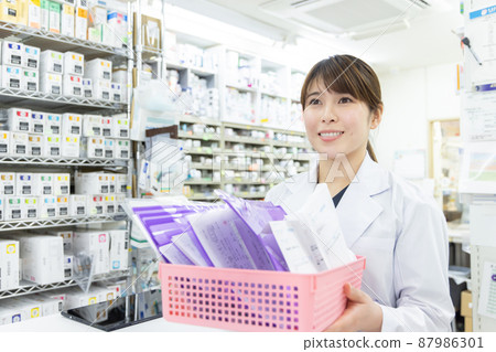 A woman working in a dispensing pharmacy 87986301