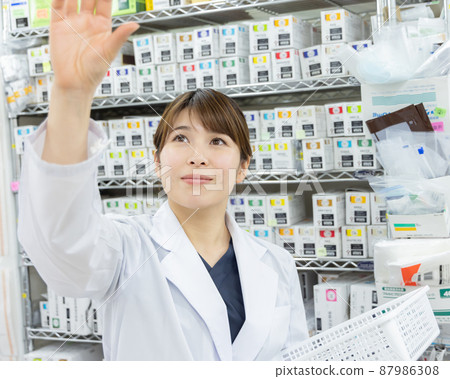 A woman working in a dispensing pharmacy 87986308