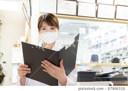 A woman working in a dispensing pharmacy 87986310