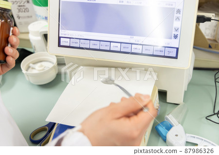 A woman working in a dispensing pharmacy A woman working in a dispensing pharmacy 87986326