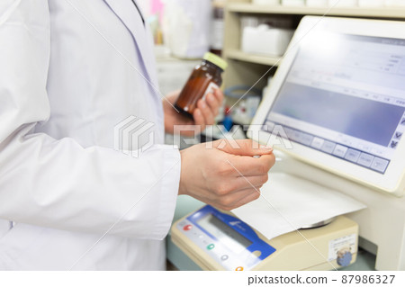 A woman working in a dispensing pharmacy A woman working in a dispensing pharmacy 87986327