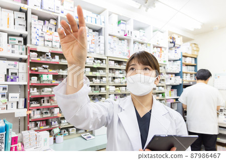 A woman working in a dispensing pharmacy 87986467
