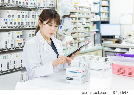 A woman working in a dispensing pharmacy A woman working in a dispensing pharmacy 87986473