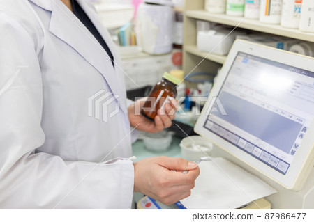 A woman working in a dispensing pharmacy 87986477