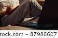 Woman working from home overtime at laptop and makes notes. 87986607