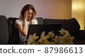 Woman working on laptop alone in dark living late at night 87986613