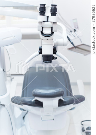 Dental binocular microscope on the background of modern dental clinic. Professional medical equipment. 87986623