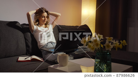 Tired freelancer finishes her online work on laptop. Tired freelancer finishes her online work on laptop. 87986626