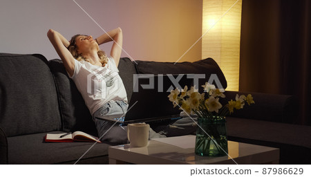 Tired freelancer finishes her online work on laptop. 87986629