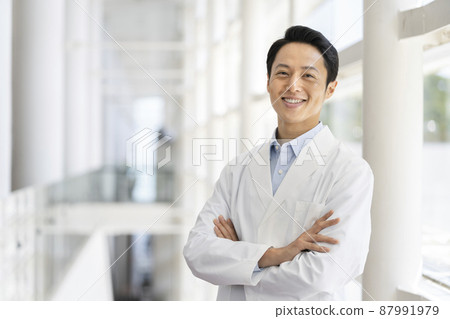 Image of a male medical worker / researcher in his thirties smiling looking at the camera in a white coat Image of a male medical worker / researcher in his thirties smiling looking at the camera in a white coat 87991979