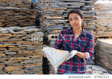 Hispanic woman worker posing with natural stone tile 87992321