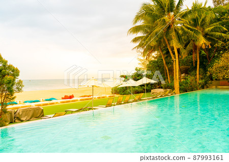 Umbrella and chair around swimming pool with sea ocean view Umbrella and chair around swimming pool with sea ocean view 87993161