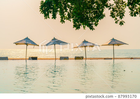 Umbrella and chair around swimming pool with sea ocean view Umbrella and chair around swimming pool with sea ocean view 87993170
